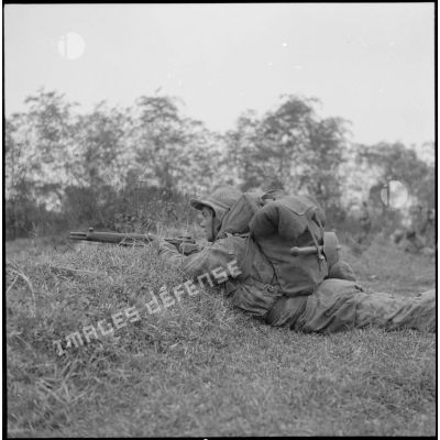 Un parachutiste du 10e bataillon colonial de commandos parachutistes (10e BCCP) muni d'un fusil MAS-36 en position de tir allongé lors de l'assaut sur le village de Moi Phat.