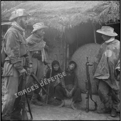 Des tirailleurs découvrent des Vietnamiens apeurés dans le village d'Ap Von Long après que les soldats du Viêt-minh aient pris la fuite.
