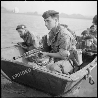 Les commandos marine abordent la côte à bord d'une barge M2 au cours d'un exercice en baie d'Along, fusil-mitrailleur en tête.