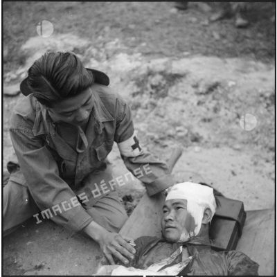 Soins médicaux prodigués à un blessé du Viêt-minh par un infirmier vietnamien.