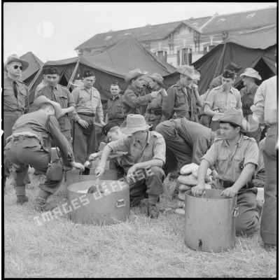 Des soldats des troupes coloniales arrivées en renfort récemment débarquées prennent le repas au cantonnement d'Haïphong.