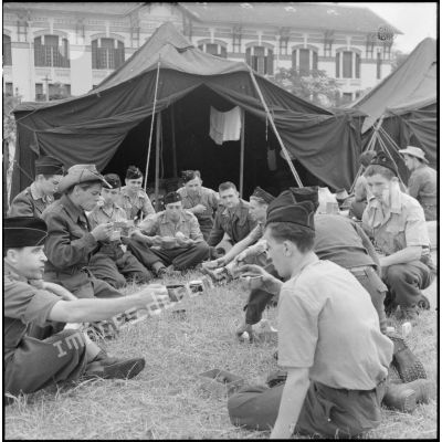 Des soldats des troupes coloniales arrivées en renfort récemment débarquées prennent le repas au cantonnement d'Haïphong.