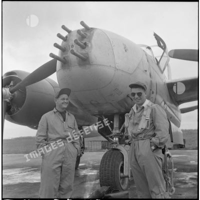 Deux navigateurs posent devant un avion bombardier Douglas A-26B avant le départ, sur la base aérienne de Cat Bi.