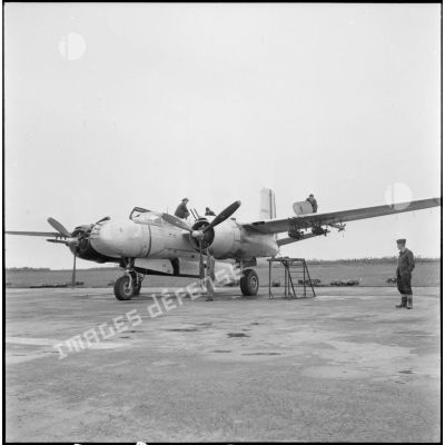 Avion A-26B avec ses mécaniciens sur le terrain d'aviation de Cat Bi.