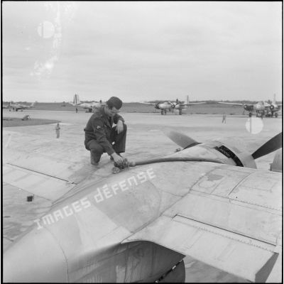 Vérification du plein d'essence d'un avion bombardier Douglas A-26B invader sur la base aérienne de Cat Bi.