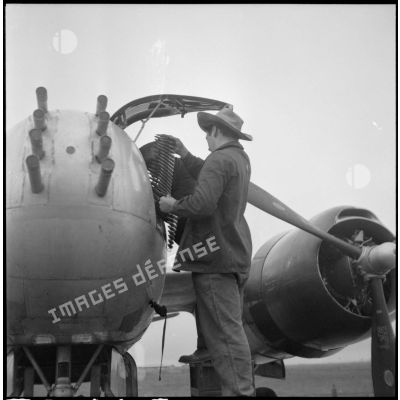 Chargement des mitrailleuses avant d'un avion bombardier Douglas A-26B Invader sur la base aérienne de Cat-Bi.