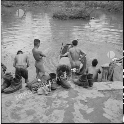 Des tirailleurs muong se baignent dans la rivière.