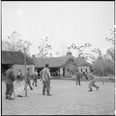 Partie de volley-ball pour les recrues muong sous la direction d'un lieutenant.