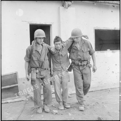 Deux légionnaires du 2e BEP soutiennent un soldat vietnamien blessé.