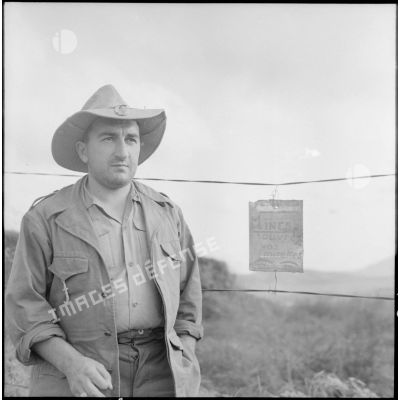 Soldat (du groupement "Sizaire" ?) devant une pancarte indiquant un champ de mines.