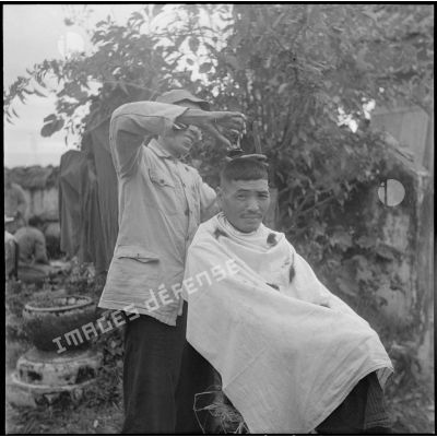 Un soldat nationaliste chinois interné à Moncay se fait couper les cheveux.