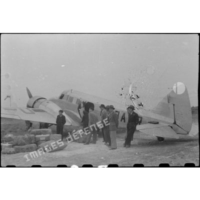 Chargement d'un avion Douglas C47 Dakota sur le terrain de Nam Dinh en présence de notables vietnamiens.