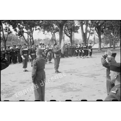 Le général Alessandri salue les nouveaux drapeaux au cours d'une cérémonie à Hanoï.