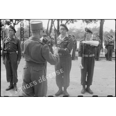 Le général Alessandri décore de la Croix de guerre le fanion du 3e BCCP (bataillon colonial de commandos parachutistes) au cours d'une prise d'armes à Hanoï.