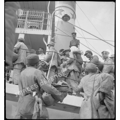 Embarquement des soldats nationalistes chinois à bord du cargo Docteur Roux, ancré dans le port de Haïphong.