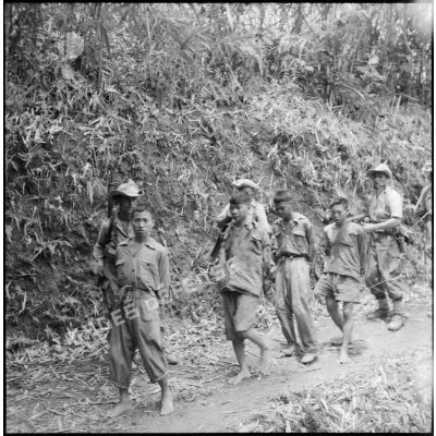 Sur la piste de Laï Chau, des goumiers du 17e tabor ramènent sur les arrières quatre prisonniers du Viêt-minh capturés la veille.