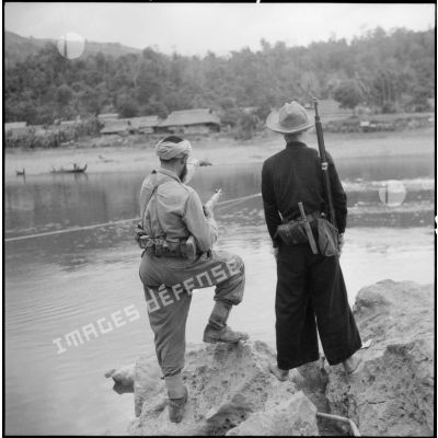 Un goumier du 17e tabor et un partisan observent le village de Chieng Nuoi situé sur le versant opposé de la rivière Nam Na.