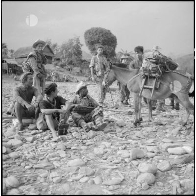 Des soldats du 17e tabor, du 8e bataillon de parachutistes coloniaux (8e BPC) et des partisans font une pause sur une rive de la rivière Nam Na.