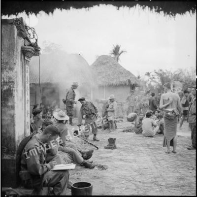 Les troupes ayant passé la nuit dans le village d'An Lao préparent le café tandis que le commandant Fourcade transmet par radio les différentes instructions pour la marche à suivre dans la journée.