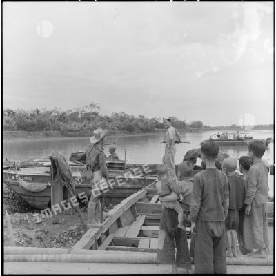 Accostage de véhicules amphibies de la 2e compagnie du groupe de transport 515 au cours de l'opération Chinchilla, sous le regard d'un groupe d'enfants vietnamiens.