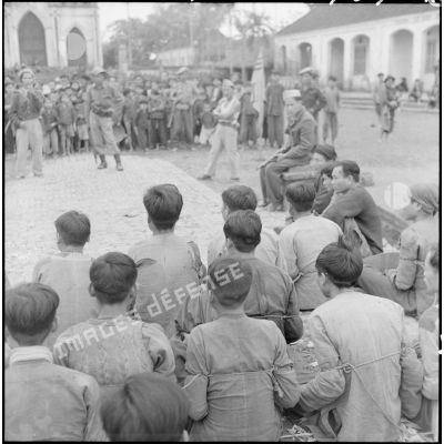 Regroupement de prisonniers Viêt-minh dans le village catholique de Thuong Vi sous la surveillance de soldats vietnamiens.