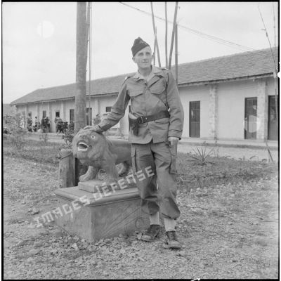 Portrait du capitaine Boissennet posant près d'une statue de lion au poste de Phu Ly.