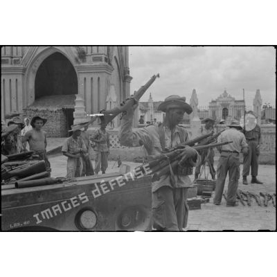 Déchargement de fusils récupérés à l'ennemi sur la place de l' église de Ke Sat.