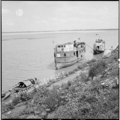 Sur les berges du fleuve Rouge, un bateau pour le transport des civils.