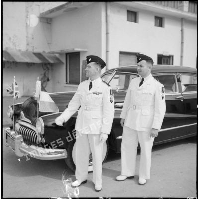 Deux sous-officiers devant la voiture officielle arborant le drapeau britannique et le drapeau français.