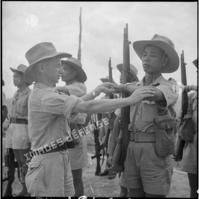 Un officier montre à un soldat comment exécuter le "présentez-armes".
