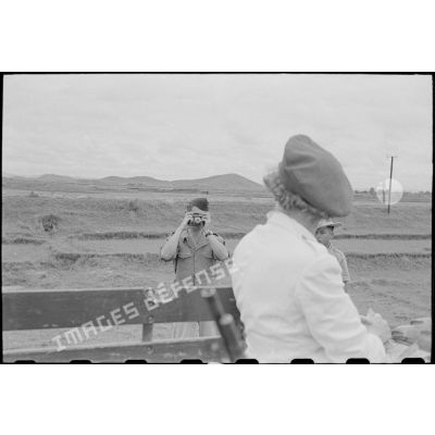 Un soldat prend un personnel féminin en photo.