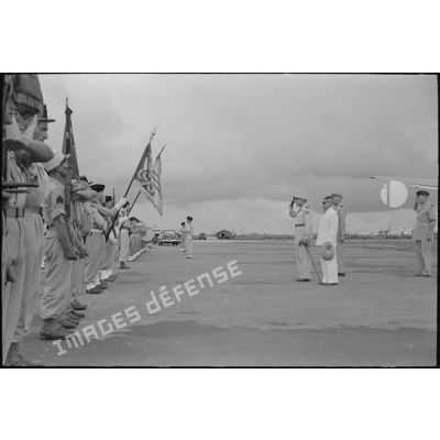 Le général de Lattre saluant les troupes et le drapeau d'un bataillon à l'aéroport d'Hanoi.