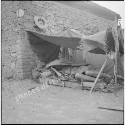 <br>Repos d'un soldat sous une tenture.
