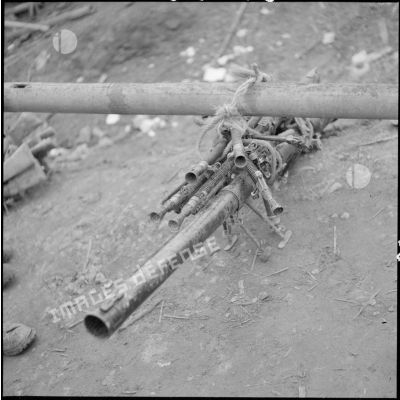 Fusils et canon liés par une corde à un bambou.