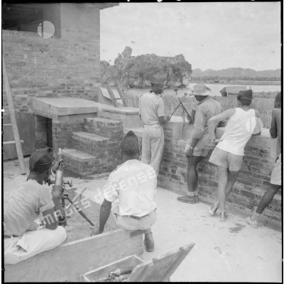 A l'intérieur de fortifications, les tirailleurs sénégalais armés de mortiers surveillent les environs du rocher de Ninh Binh que l'on distingue en arrière plan.