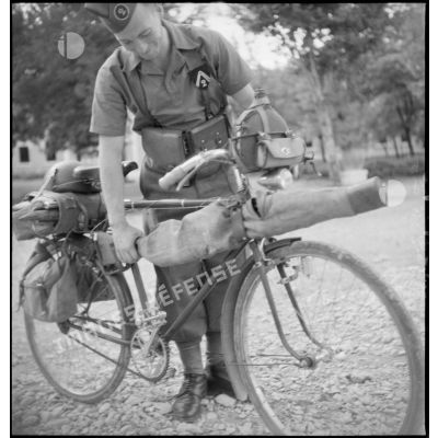 Un concurrent de l'épreuve fixe son armement sur sa bicyclette avant le départ de l'épreuve.