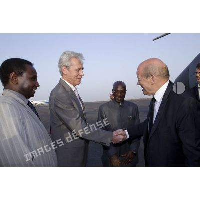 Le ministre de la Défense Jean-Yves Le Drian est accueilli par des cadres de la mission de formation de l'Union européenne (EUTM) à son arrivée à l'aéroport de Bamako, au Mali.