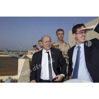 Le ministre de la Défense Jean-Yves Le Drian observe le camp français sur l'aéroport de Bamako aux côtés du général Grégoire de Saint-Quentin, au Mali.