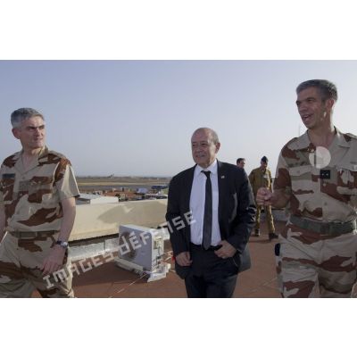 Le ministre de la Défense Jean-Yves Le Drian observe le camp français sur l'aéroport de Bamako aux côtés des généraux Antoine Noguier et Grégoire de Saint-Quentin, au Mali.