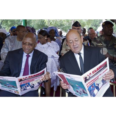 Le ministre de la Défense Jean-Yves Le Drian lit le journal Le Clairon aux côtés du ministre malien Soumeylou Boubeye Maïga lors d'une cérémonie au camp du 34e bataillon du Génie militaire à Bamako
