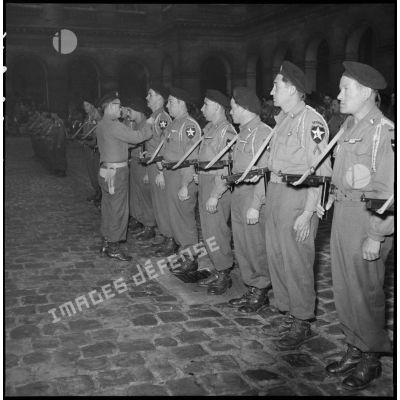 Les volontaires du 1er Bataillon français des Nations Unies (Bataillon de Corée) sont décorés lors d'une prise d'armes dans la cour d'honneur de l'Hôtel national des Invalides.