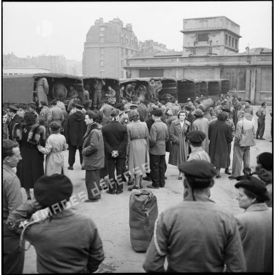 Après leur arrivée en gare de Lyon (Paris), les volontaires du 1er Bataillon français de l'ONU de retour en France embarquent en camions pour le fort de Vincennes.