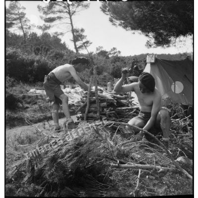 Des fantassins coupent du bois sur le campement du 43e RIA.