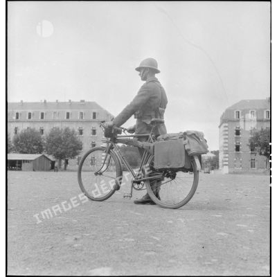 Présentation d'un vélo transportant armement et équipement individuel.