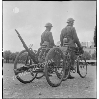 Présentation de vélos avec remorque transportant un fusil MAS 36 et la plaque de base d'un mortier léger.