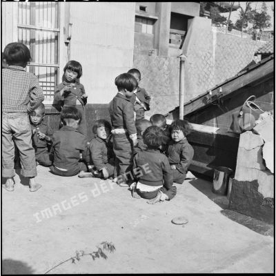 Enfants sud-coréens mangeant des biscuits dans une cour en Corée.