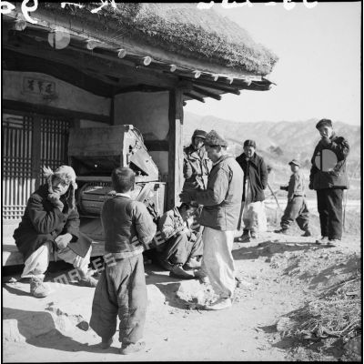 Groupe de Coréens devant une habitation dans un village.