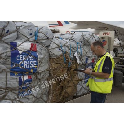 Un agent des services aéroportuaires encadre le chargement de fret à bord d'un avion sur l'aéroport de Roissy-Charles-de-Gaulle.