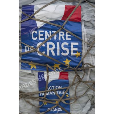 Affiche sur une palette de fret humanitaire en chargement à l'aéroport de Roissy-Charles-de-Gaulle.