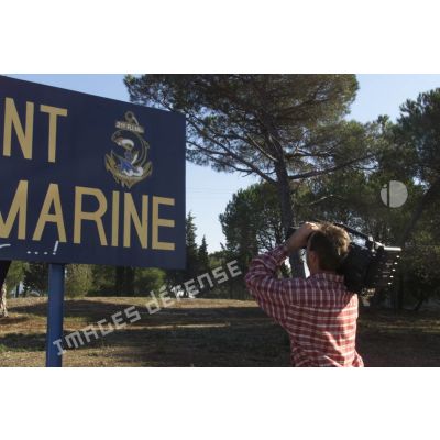 Préparatifs au départ en Afghanistan pour le 21e RIMa (régiment d'infanterie de marine). Un caméraman filme le panneau d'entrée du camp du 21e RIMa, portant son insigne avec la devise "croche et tient".